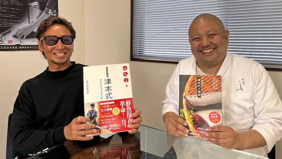 「津本式」の本を持つ津本さんと、熟成の本を持つ木宮大将の写真